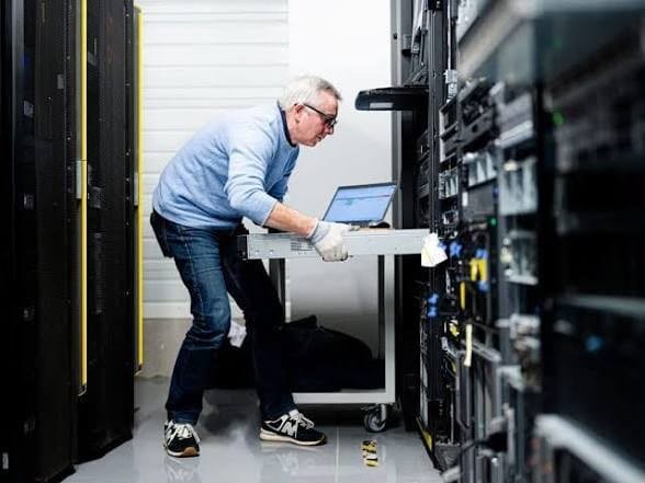 Technicien intervenant sur un serveur en salle informatique
